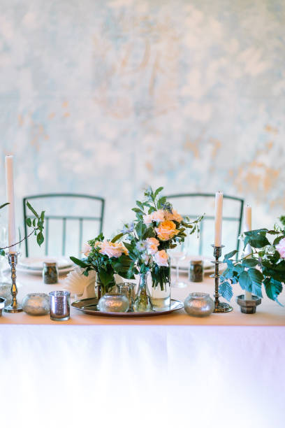 istock beautifully illuminated festive wedding table covered with delicate fabric. Focus on flower arrangements and candles. Welcome dinner design concept 1226279906