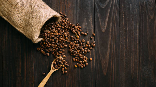 istock Vintage sack with coffee beans spilling on wooden table 1226282258