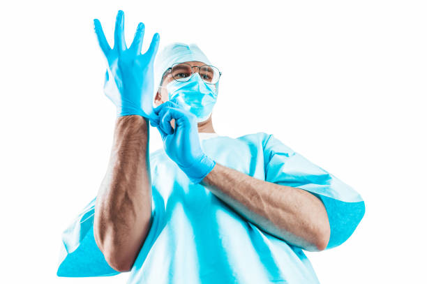 Portrait of a doctor on a white background. He pulls on the glove. Medicine concept. stock photo
