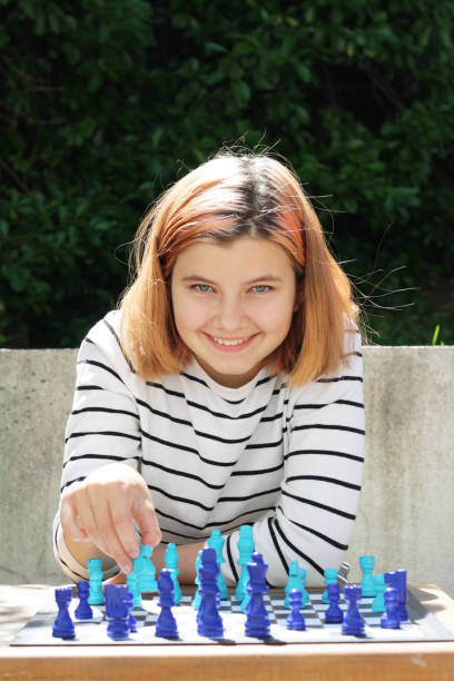 istock Young girl playing chess, looking at camera. 1226284946