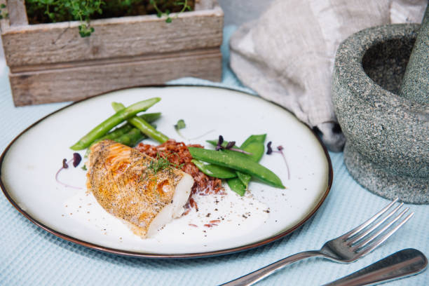 Halibut white fish in coconut sauce with ruby rice and blanched asparagus