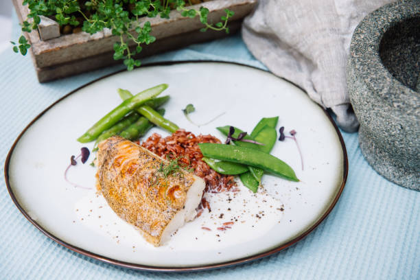 istock Halibut white fish in coconut sauce with ruby rice and blanched asparagus 1226285040