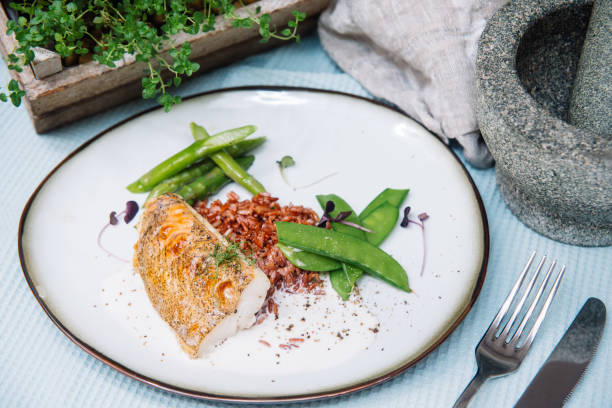 istock Halibut white fish in coconut sauce with ruby rice and blanched asparagus 1226285072