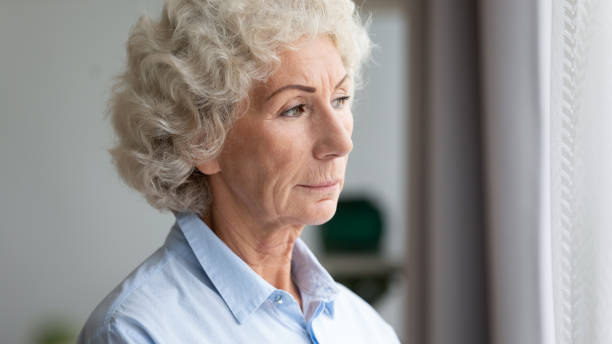 istock Pensive senior woman look in window thinking 1226286133