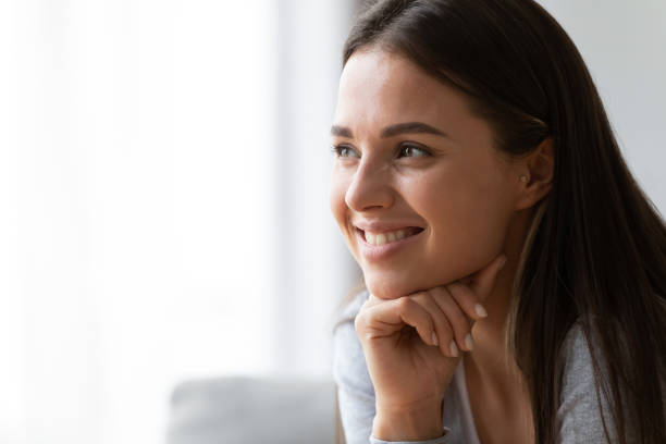 Happy young woman look in distance dreaming or visualizing