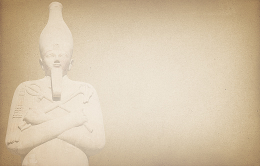 Osiris statue on antique paper background with copy space.
