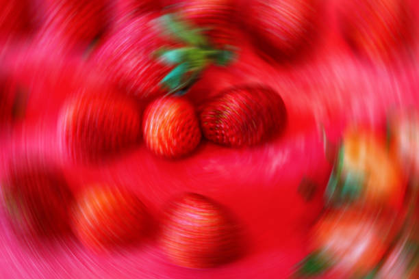Red background with radial blur of whole strawberries on red cutting board