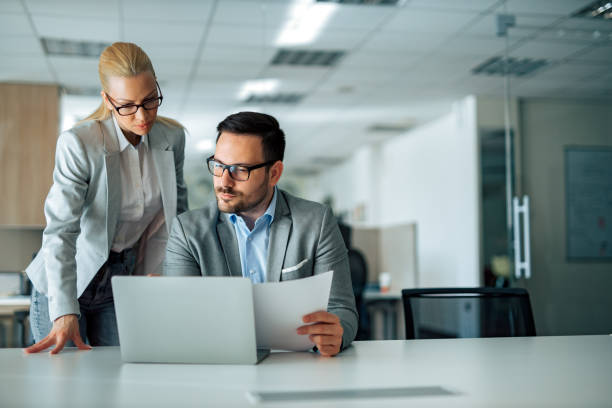 istock Two serious business people looking at work report or business plan, portrait. 1226295268
