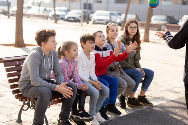 istock Children sitting on bench and playing ball 1226296216