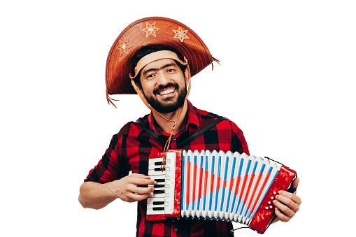 Brazilian man wearing traditional clothes for Festa Junina - June festival - playing accordion