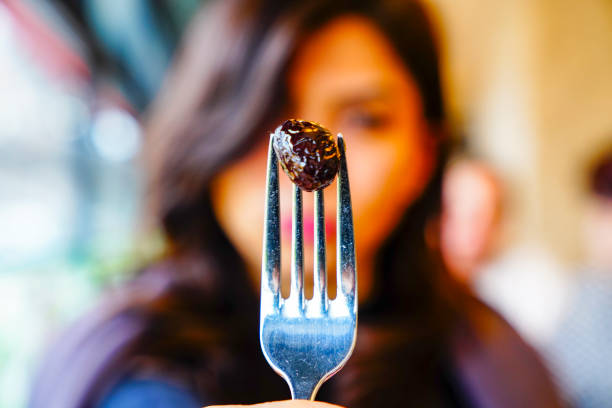 fork and olives, woman holding fork in hands and olives