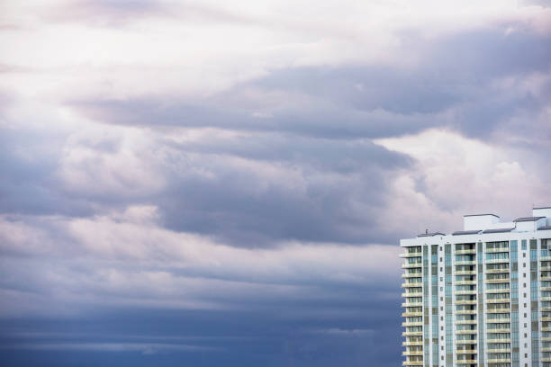 This is a photograph of part of a luxury residential building with dark tropical storm clouds developing in Miami, Florida at the beginning of hurricane season.