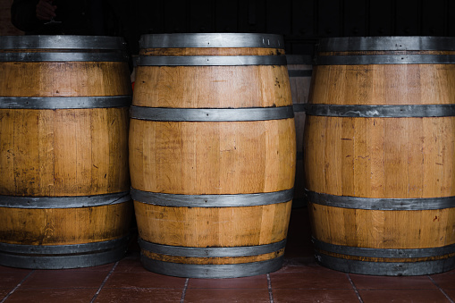 Four large wine barrels in a row used as sidewalk cafe tables. Street view in A Coruna city, Spain.