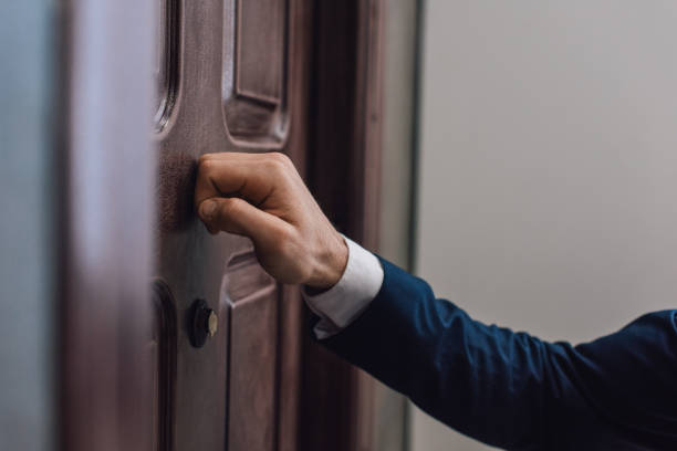 Cropped view of collector knocking on door with hand Cropped view of collector knocking on door with hand knocking on door stock pictures, royalty-free photos & images