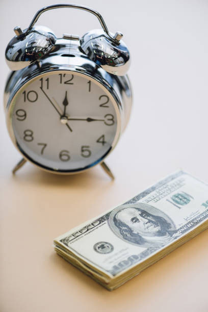 istock Dollar banknotes and alarm clock on white background 1226298367