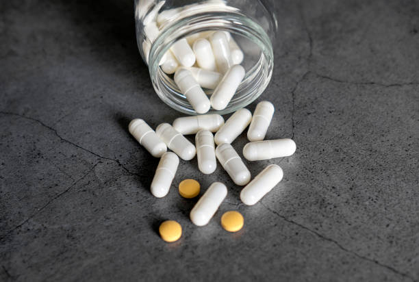 istock White and orange antibiotic pills from a jar on a dark concrete table 1226299926