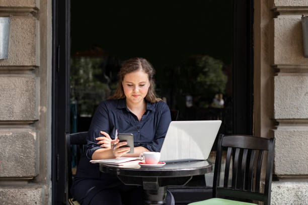 istock Happy Plus Size Woman Sitting in a Cafe and Using her Smartphone 1226301128