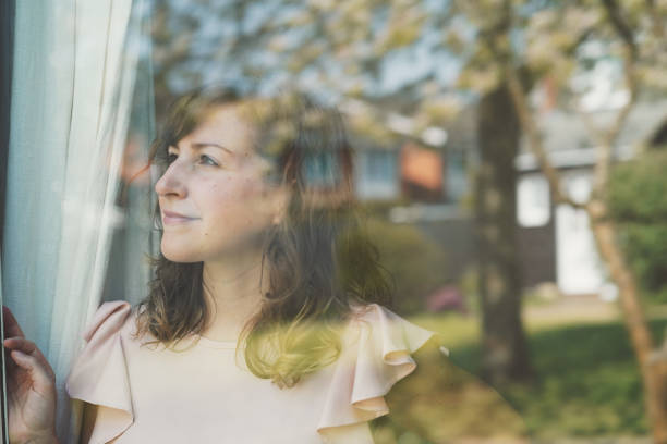 istock Young woman looking outside with hope during COVID-19 Lockdown spring time Oxford 1226301443