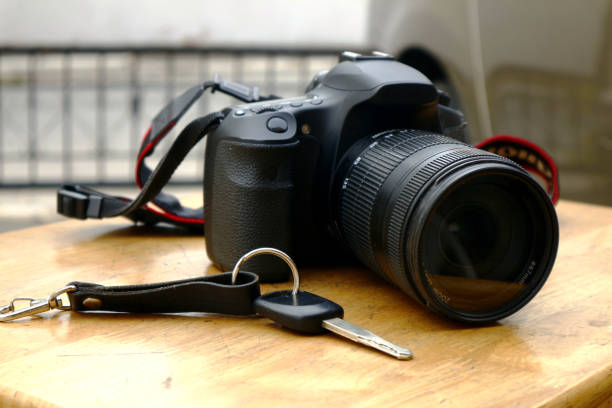 istock Digital SLR or DSLR camera and a car key on a wooden table 1226316348