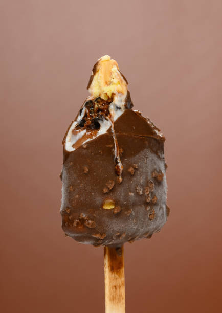 istock half eaten chocolate outer popsicle with blueberry sauce inside on brown background close up 1226318128