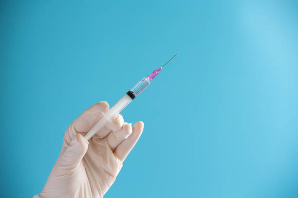 istock Doctor hand hold Syringe vaccine for corona virus on isolate blue background concept for Coronavirus pandemic disease, COVID-19 virus from epidemic outbreak to wide concept for social scientist vaccine 1226318356