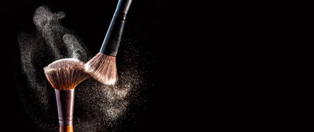 make up cosmetic brushes with powder blush explosion on black background. skin care or fashion concept. free space for your text - face powder exploding make up dust imagens e fotografias de stock