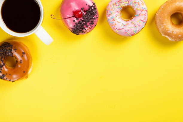 istock Cup with coffee and donuts on yellow background. Top view and free space for your text 1226321185