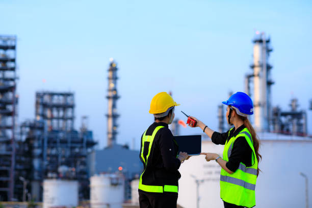 Smart two female engineer discussion together at refinery industry plant at industry factory center area. Engineering Concept Smart two female engineer discussion together at refinery industry plant at industry factory center area. Engineering Concept oil industry stock pictures, royalty-free photos & images