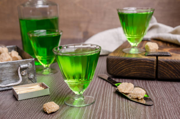 Green liquid in a glass Green liquid in a glass with sugar cubes on a dark wooden background. Selective focus. absinthe spoon stock pictures, royalty-free photos & images