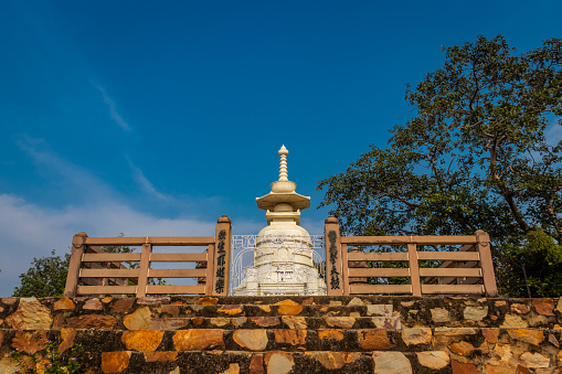 buddhist stupa isolated with amazing blue sky from unique perspective image is taken at Vishwa Shanti Stupa Rajgir in Bihar india. This stupa is symbol of world peace.
