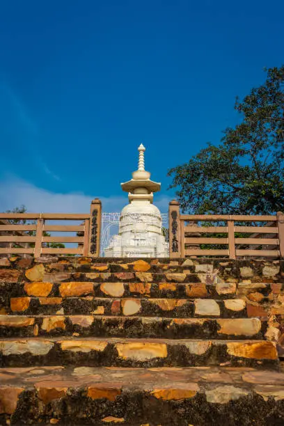 buddhist stupa isolated with amazing blue sky from unique perspective image is taken at Vishwa Shanti Stupa Rajgir in Bihar india. This stupa is symbol of world peace.
