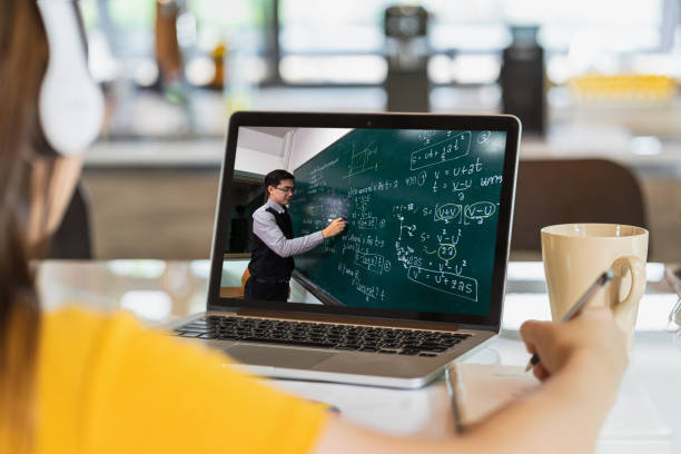 vista posteriore dell'apprendimento degli studenti asiatici con l'insegnante sul formular di fisica in thai laguage su lavagna nera tramite videoconferenza quando covid-19 pandemia, educazione e concetto di distanziamento sociale - teacher professor science university foto e immagini stock