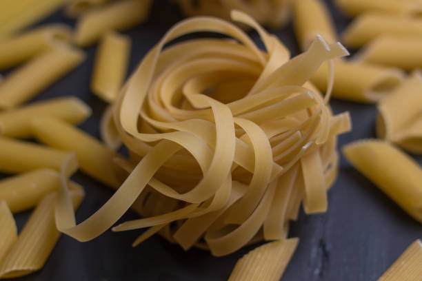 istock variety of noodles on black background - macro 1226337617