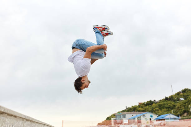 young man throwing a somersault outdoors