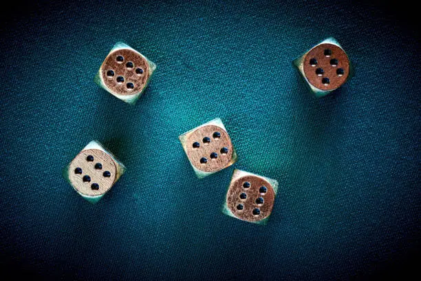 Photo of Gambler threw jackpot on casino dice on the green poker table in the las vegas. Golden chips and coins on the textile table surface. Entertainment and nightlife in vegas. Background