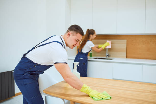 Cleaning service team at work in kitchen with white interior