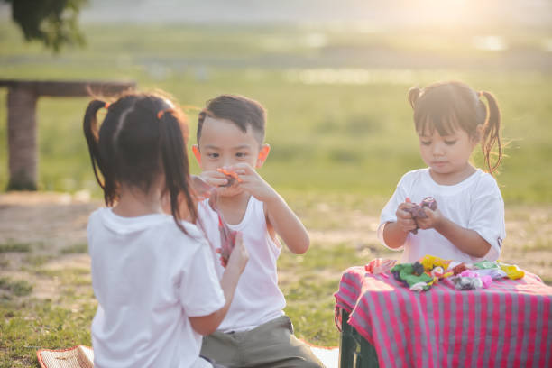 istock Asian kids makes plasticine  in park 1226349285