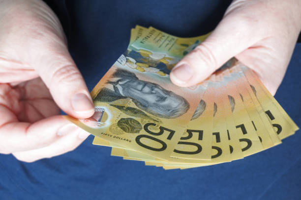 istock Australian woman counting Australian dollar banknotes 1226351528