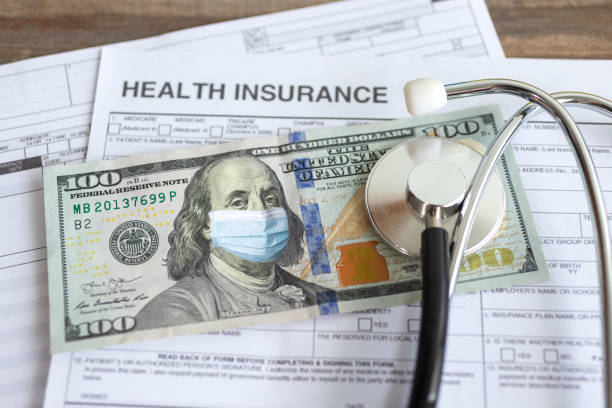 One hundred us dollars with a face mask on insurance paper bill. Healthcare costs during the coronavirus COVID-19 outbreak cost One hundred dollars with a face mask on the insurance paper bill. Health care cost during coronavirus covid outbreak concept Medical Payments Coverage stock pictures, royalty-free photos & images