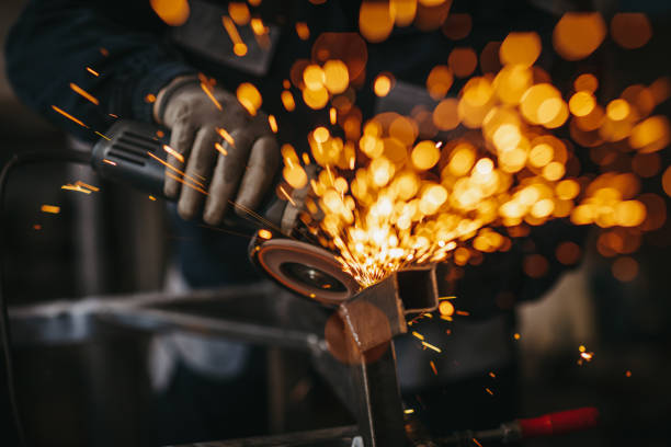 homme aîné utilisant le broyeur électrique dans l’atelier - fonderie photos et images de collection