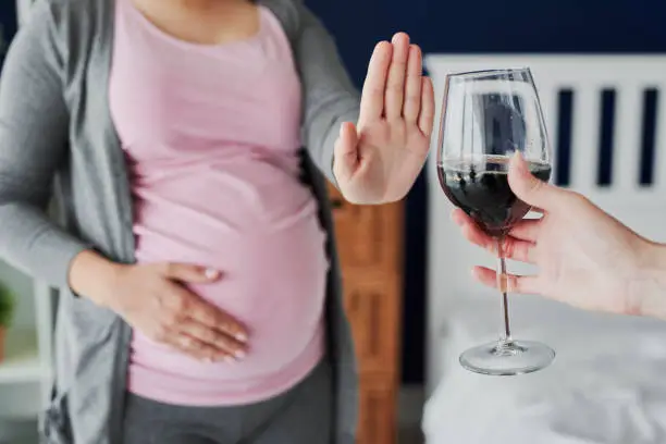 Pregnant woman refusing a glass of wine