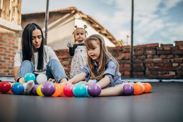 istock Mother playing with her daughters together in trampoline 1226359392