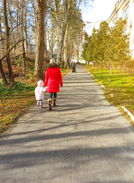 istock Woman is walking with a child outdoors. Cold weather. 1226359540