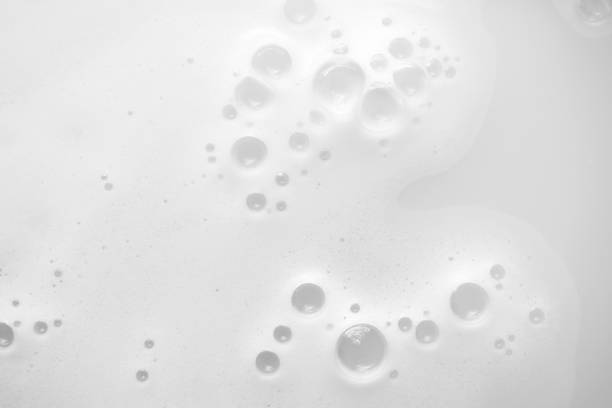 Gentle soap sud foam with bubbles from moisturizer shampoo, shower gel or facial cleanser on water, top view. Concept washing, laundry and skin care stock photo