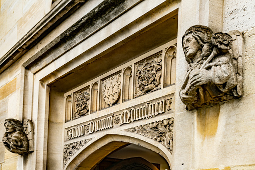 Entrance to an Oxford College with carving above the door and two busts, carved each side of the door.