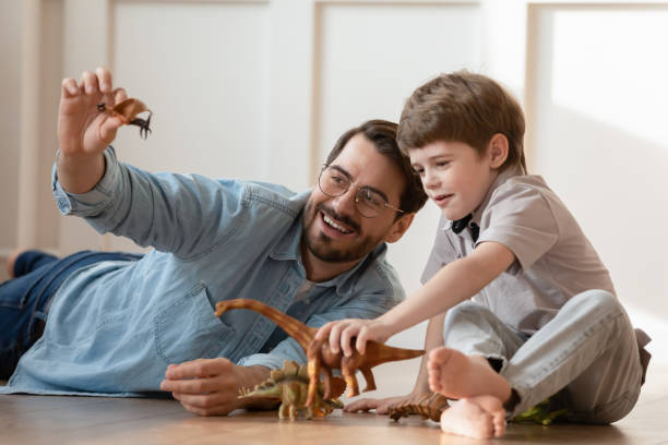 istock Young father and little son play rubber figures at home 1226364338
