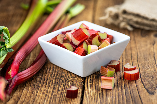 Chopped Rhubarb on an old wooden table (close up shot; selective focus)