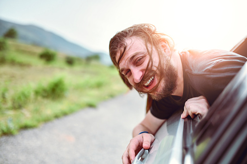 Male Having Fun With Head Out Of Window While Riding In Car