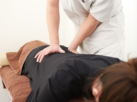 A Japanese woman getting a hip massage at a seitai clinic