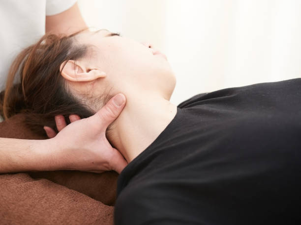 uma mulher japonesa recebendo uma massagem no pescoço em uma clínica de seitai - massaging alternative medicine headache women - fotografias e filmes do acervo